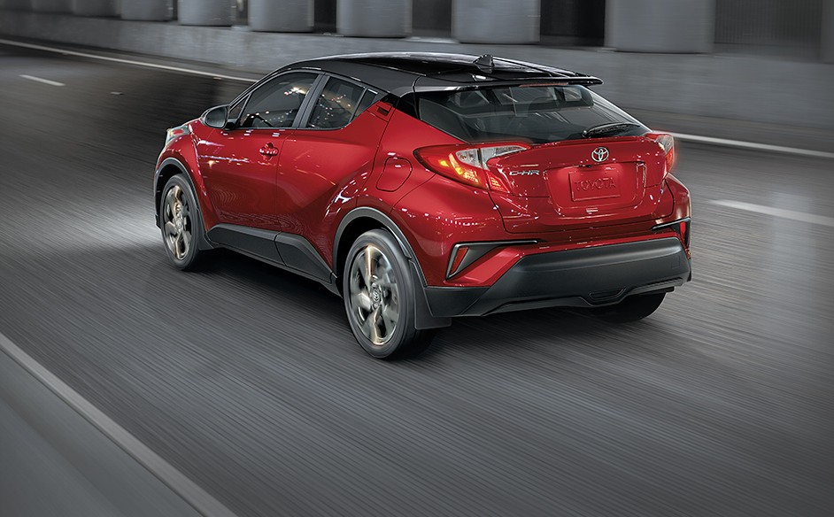 A red Toyota C-HR drives through the streets of Whitehorse, YK