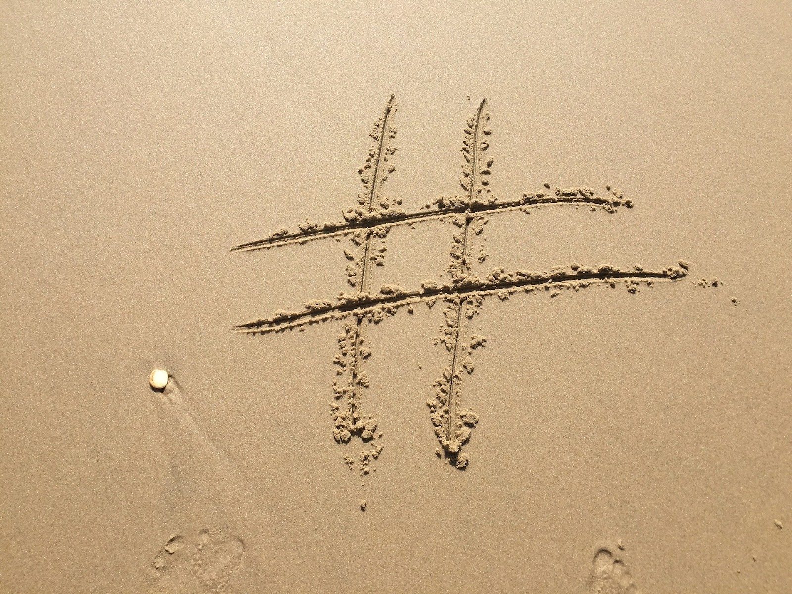 A picture of the hashtag symbol that's been drawn in the sand