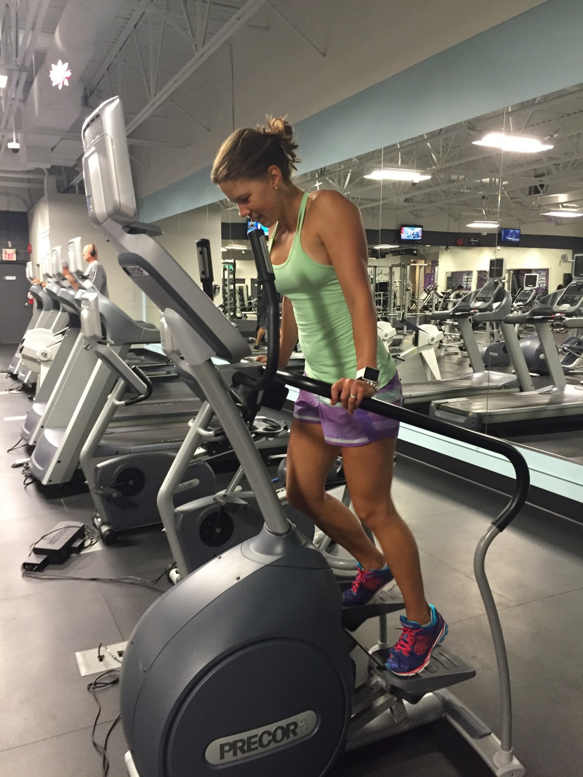 woman looking tired on treadmill at gym 