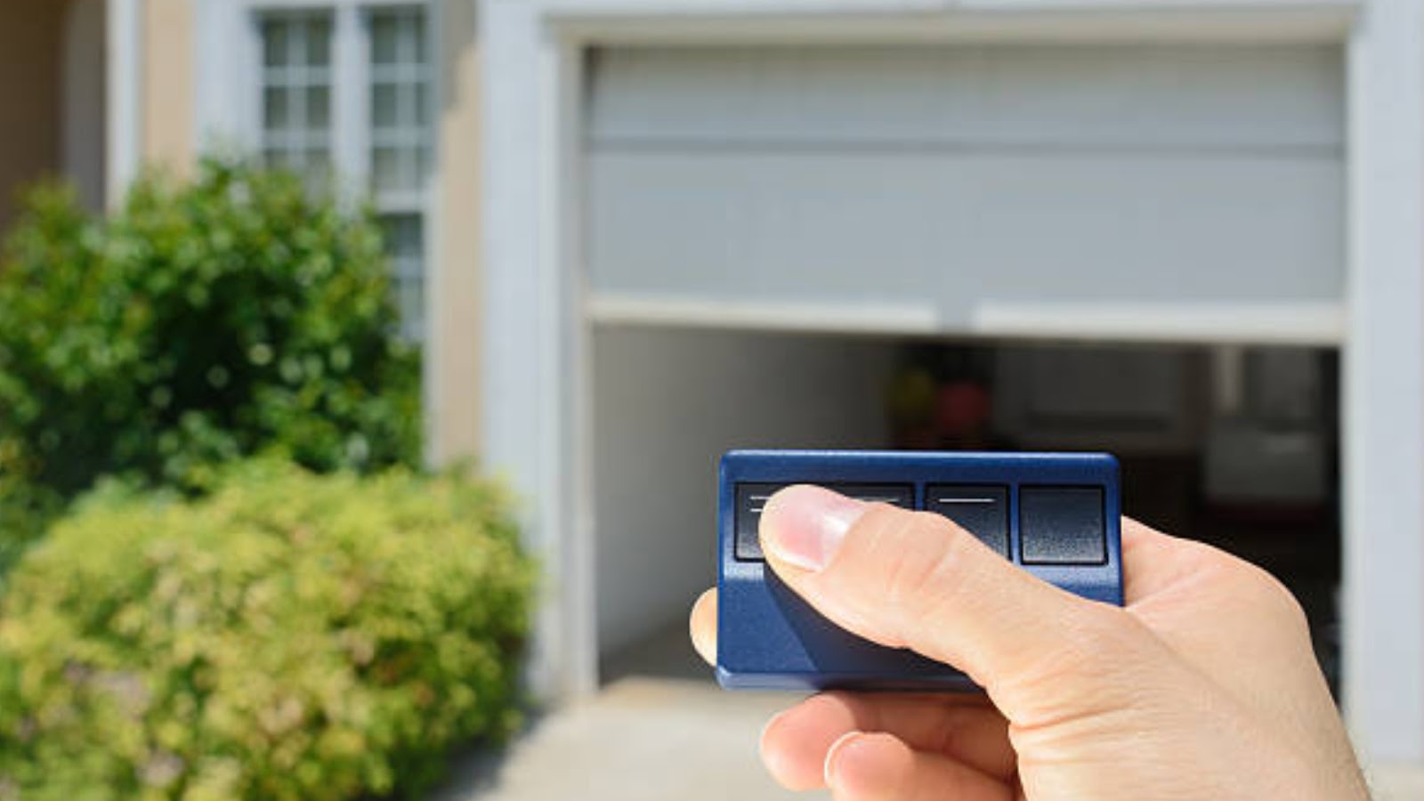 A man holding a garage door remote
