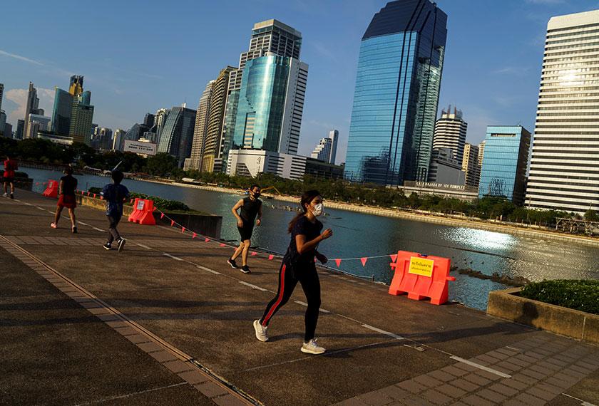 Pengunjung memulakan aktiviti berjoging dan berjalan di sekitar kawasan taman beriadah di Bangkok. Foto: REUTERS