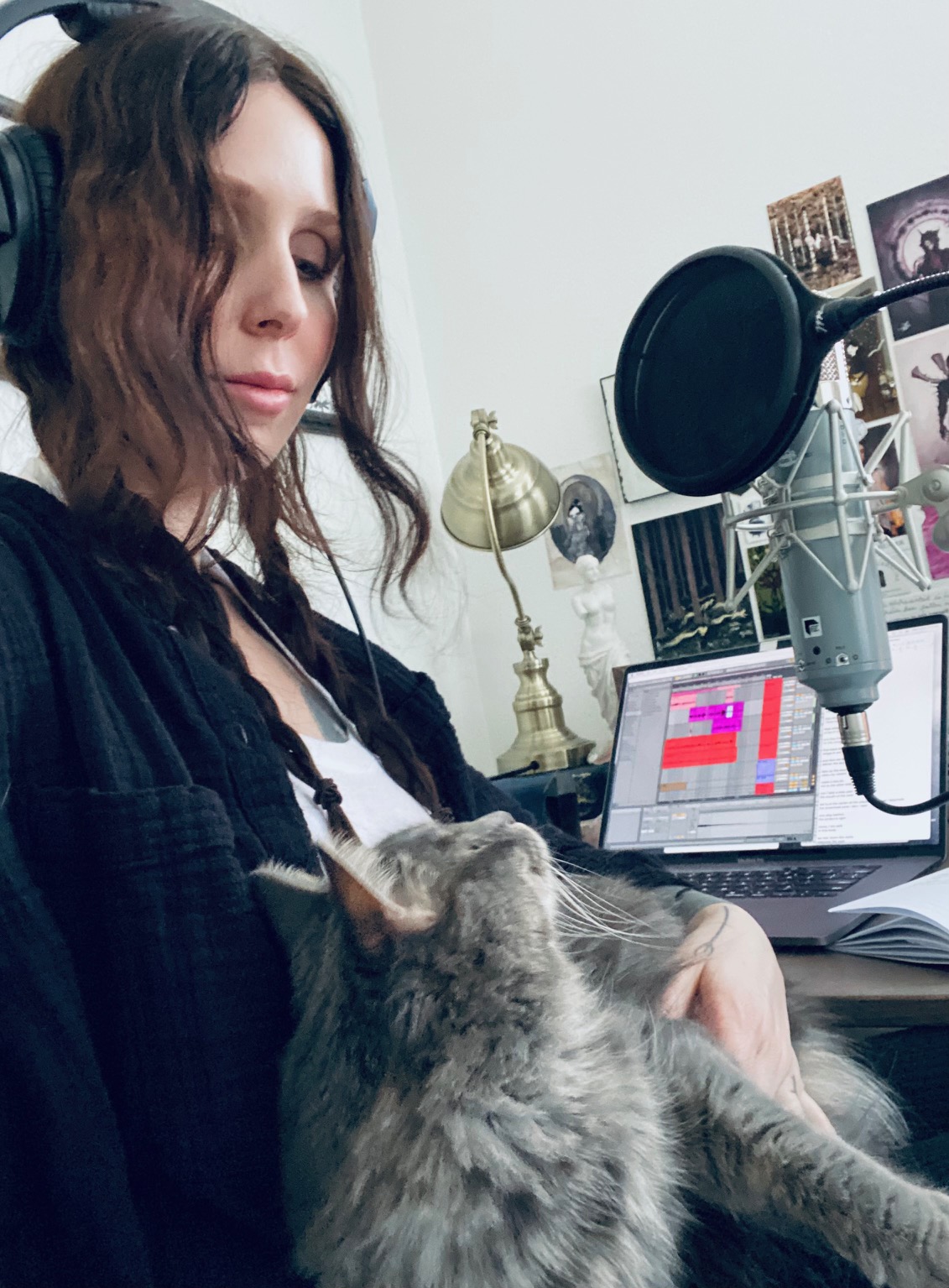 Chelsea Wolfe at her writing desk with her grey cat Wisp on her lap