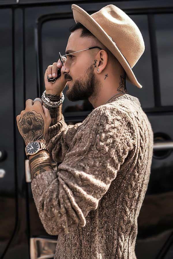 Classy man wearing wool sweater along with brown hat. 