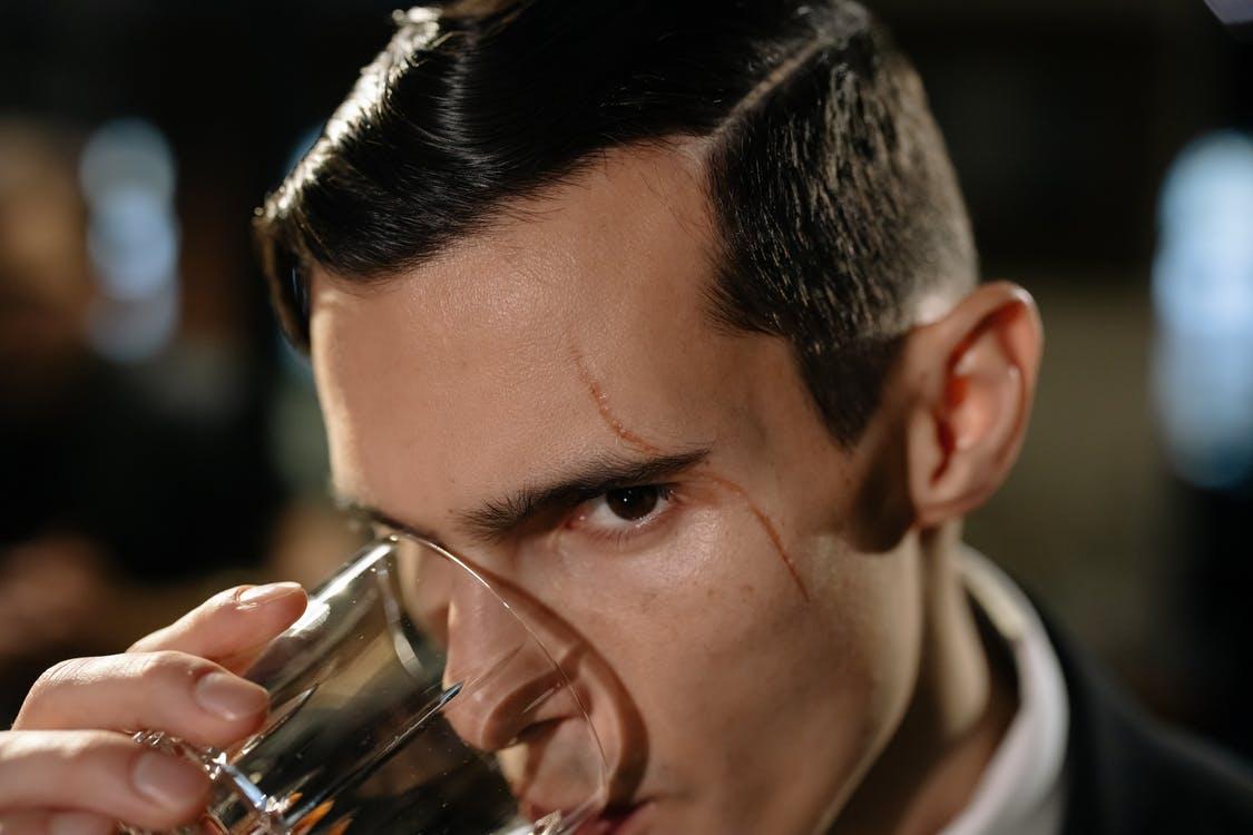 Free Close-Up Photo of Man Drinking from Glass of Whiskey Stock Photo