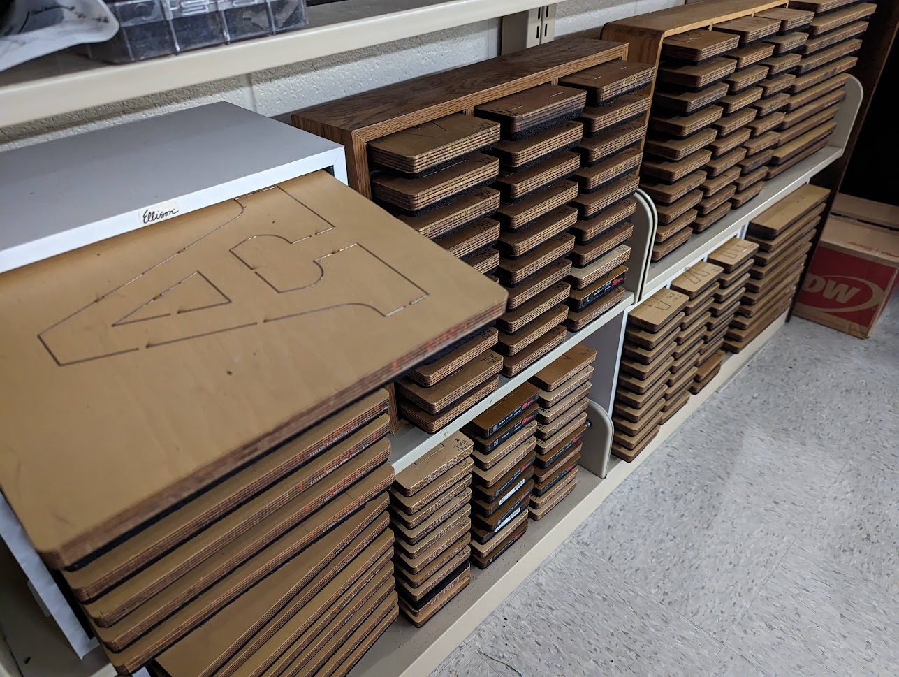 photo of well organized wall of die cutters, which look like metal cookie cutters hammered into a slab of wood.