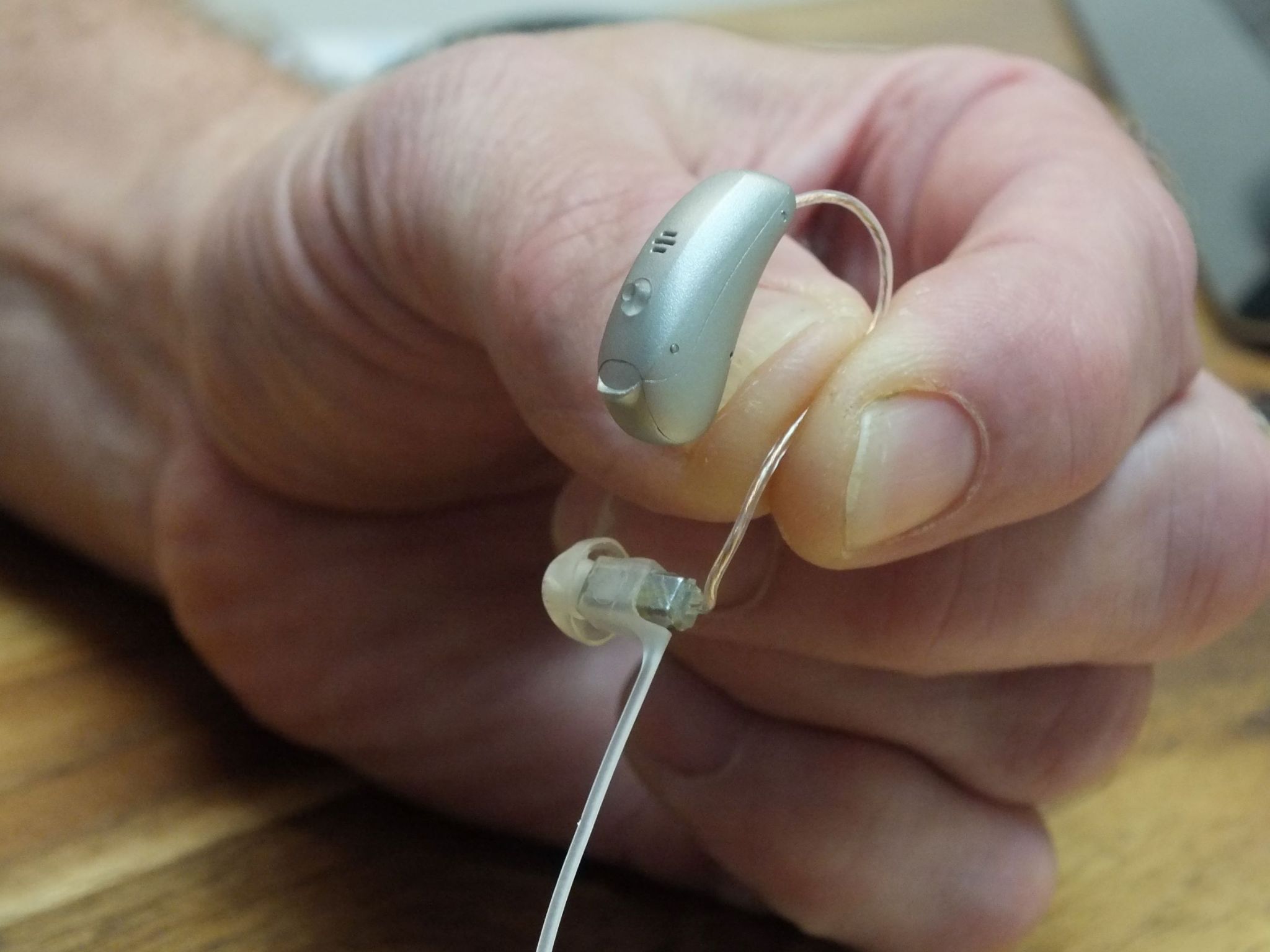 man’s-hand-holding-hearing-aid