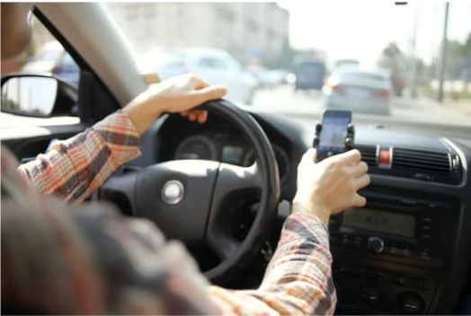 a person reaching for their phone in a car