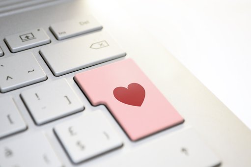 lado derecho de un teclado con una tecla rosa con un corazón rojo en él.
