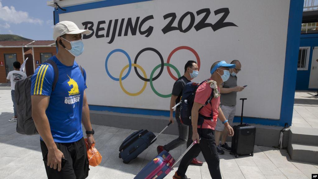到河北省张家口崇礼的游客走过北京2022冬季奥运会的广告牌。（2020年8月13日）