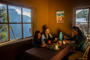 Los viajeros Etienne Casas y Lea Luong cenan con el guía local Jorge Luis Roldán en ...