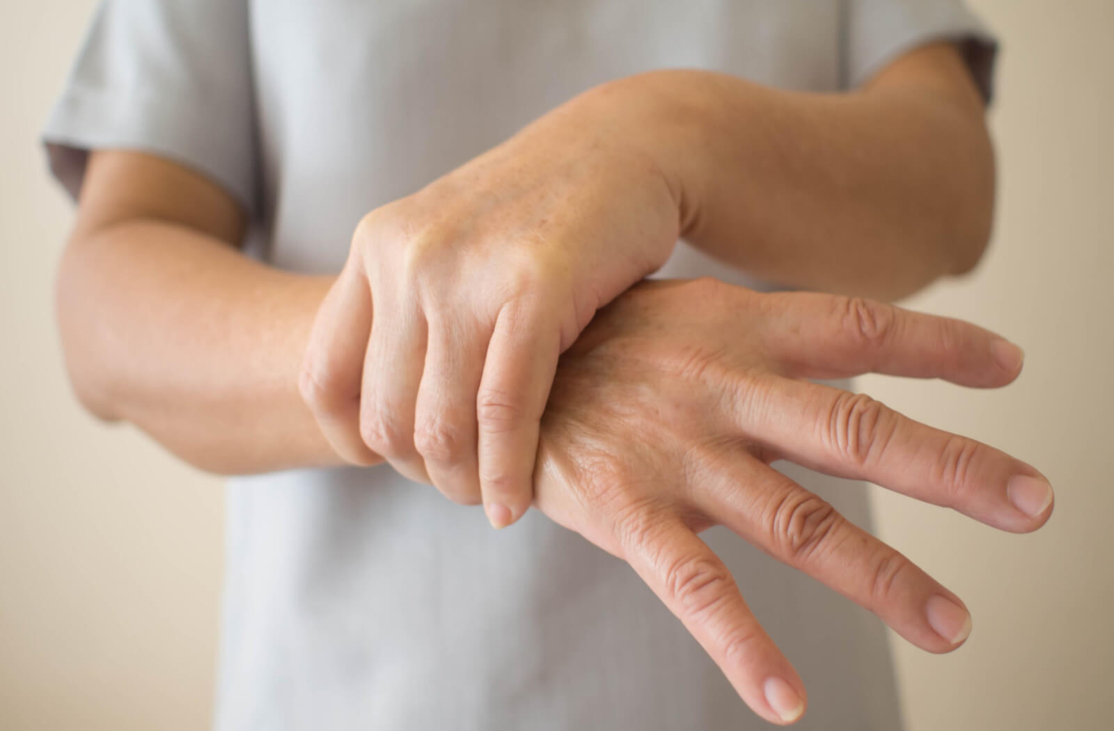 a person holds their arm due to muscle weakness
