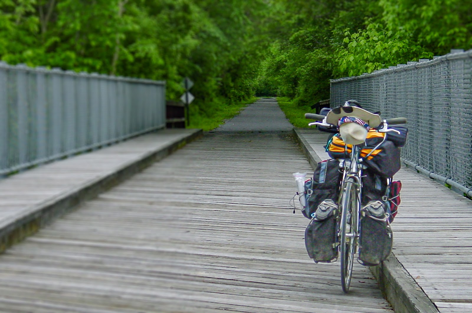 A wooden bridge with a bike loaded with camping equipment