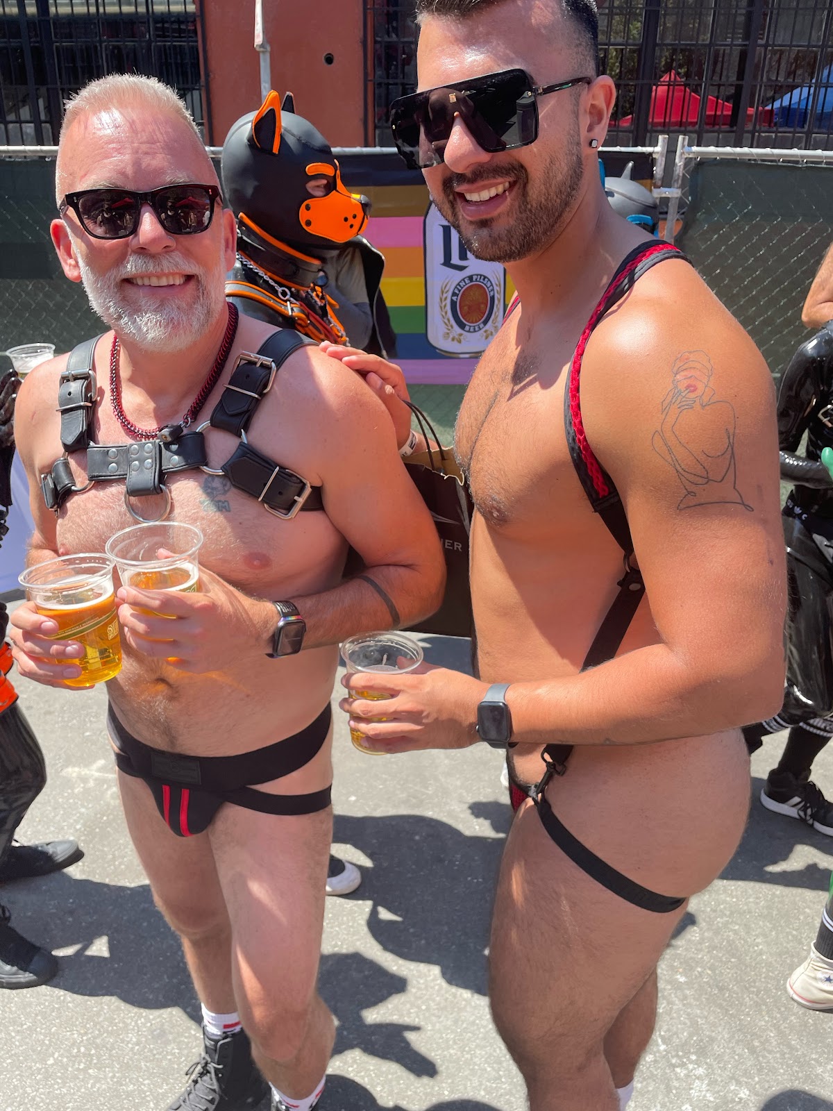 A hairy muscle cub and gay hairy leather daddy drinking beer outside at Dore Alley 2023