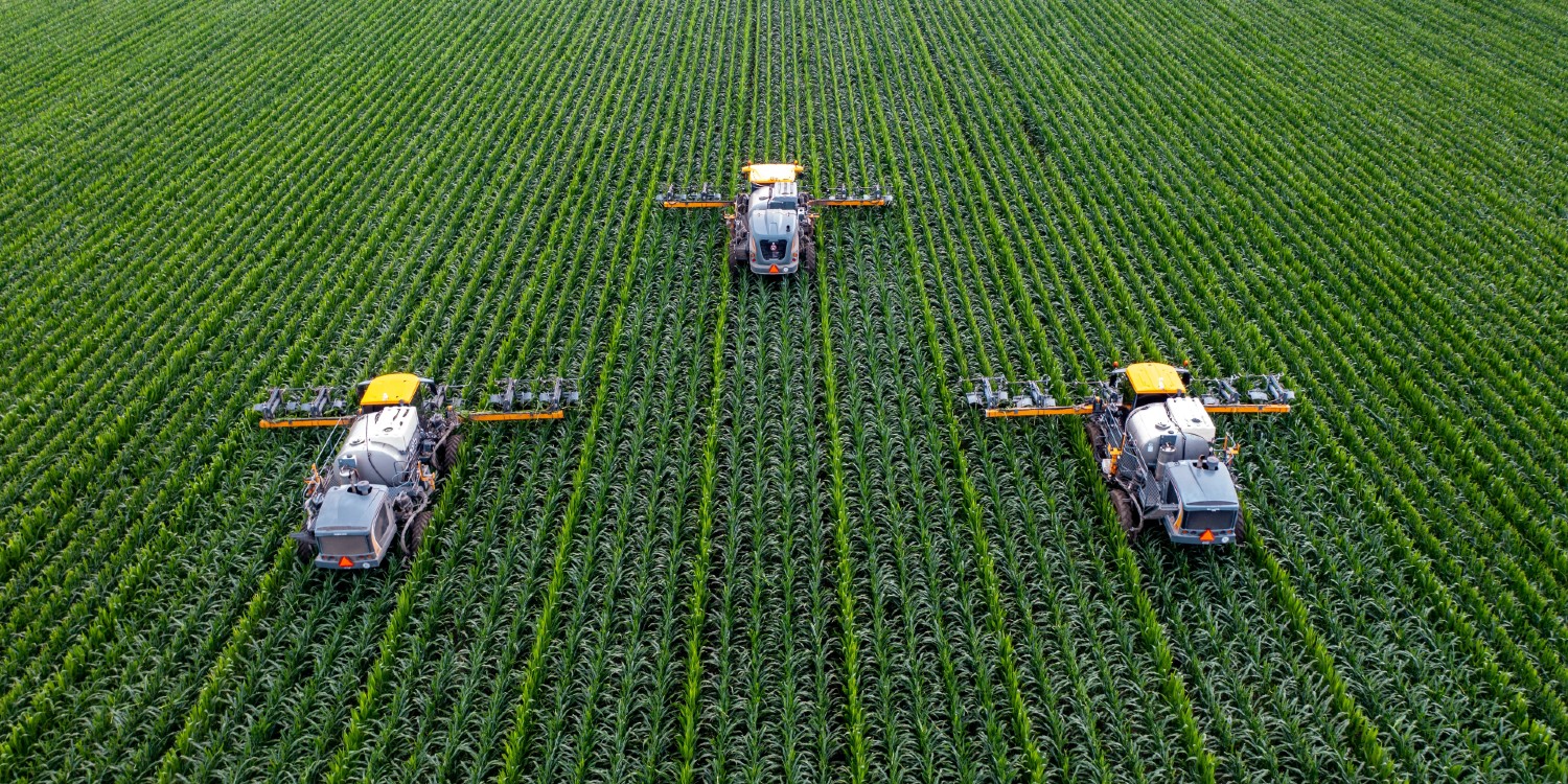 precision agrisculture with machines running down bullet straight rows of crops