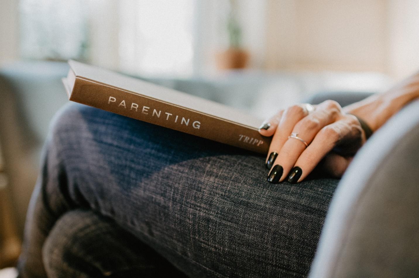 A person holding a parenting book