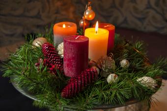Candles With Pine Cones And Wreath On Table