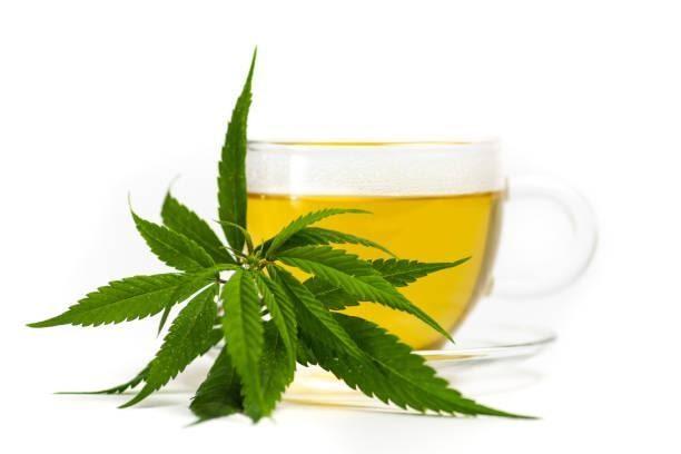 Marijuana herbal tea and cannabis leaves Marijuana herbal tea in a glass and cannabis leaves isolated cannabis tea stock pictures, royalty-free photos & images