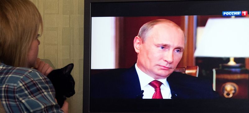 В марте 2015 года москвичка смотрит на государственном телеканале документальный фильм о аннексии Крыма Россией, в котором Путин признался, что рассматривал возможность приведения ядерного оружия в боевую готовность (Дмитрий Серебряков/AFP/Getty).