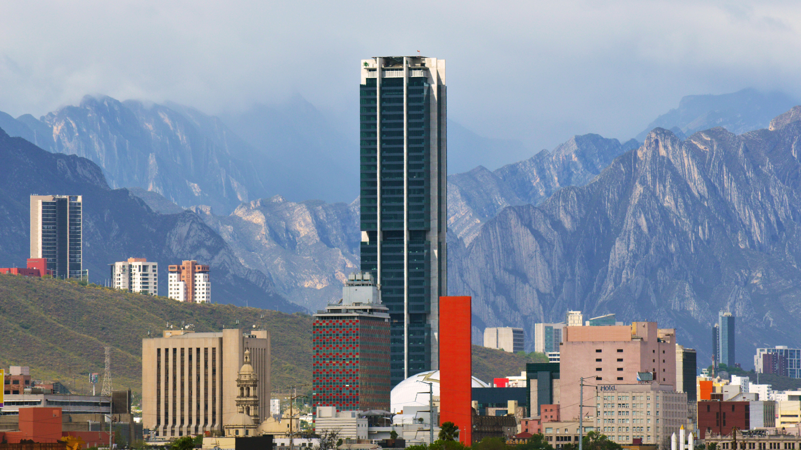 Photo of buildings in front of a mountain range landscape.
