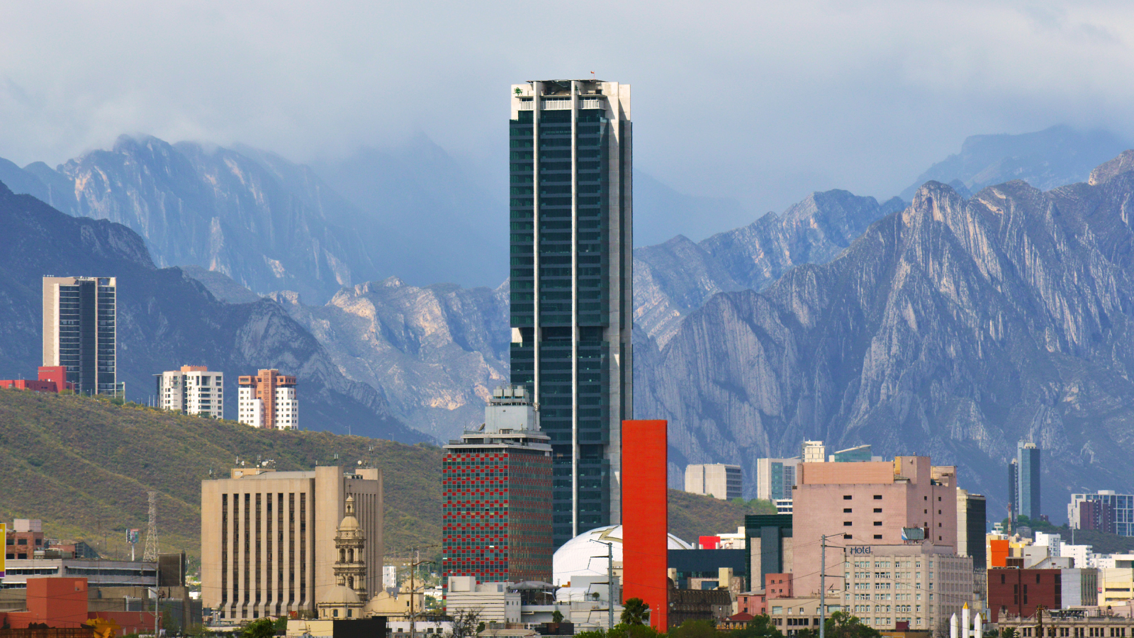 Fotografía de edificios frente a un paisaje montañoso.