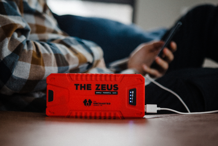 Zeus portable jump starter being used to charge a phone
