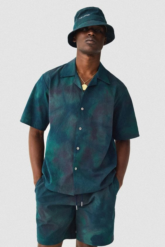 man wearing dark green bucket hat with matching outfit
