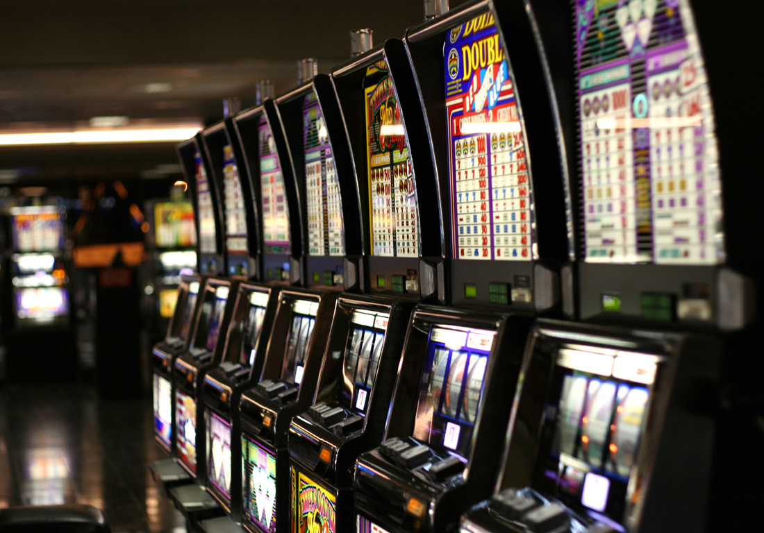 A row of nine slot machines in an empty casino 