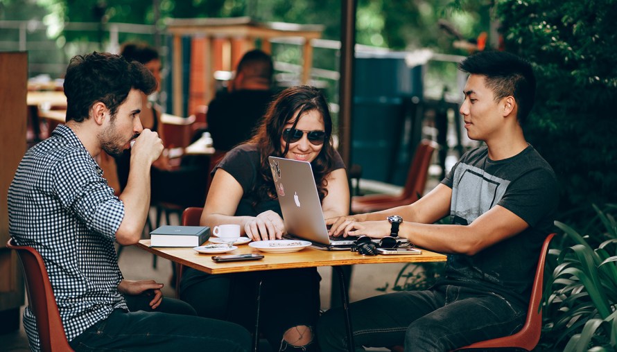 Friends gathered around a laptop