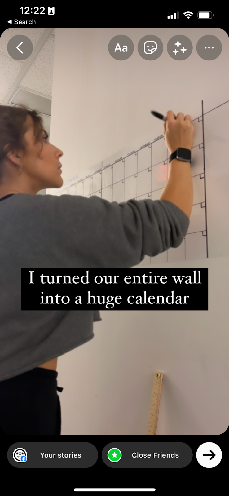 Screenshot of Inspired Idiots Kelsey creating a large wall calendar for the office space, added into Instagram Story editing with text overtop that reads “I turned our entire wall into a huge calendar."
