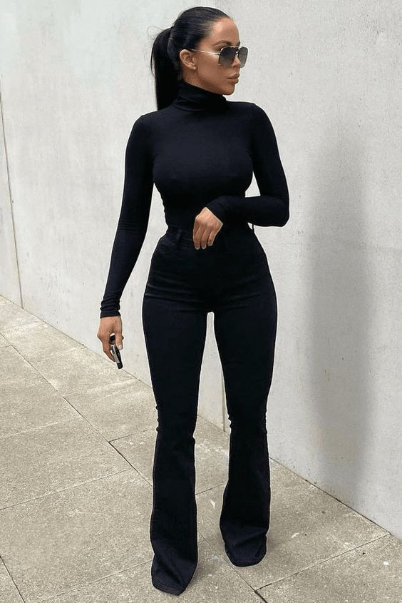Woman in black high-waisted bootcut jeans with turtleneck top