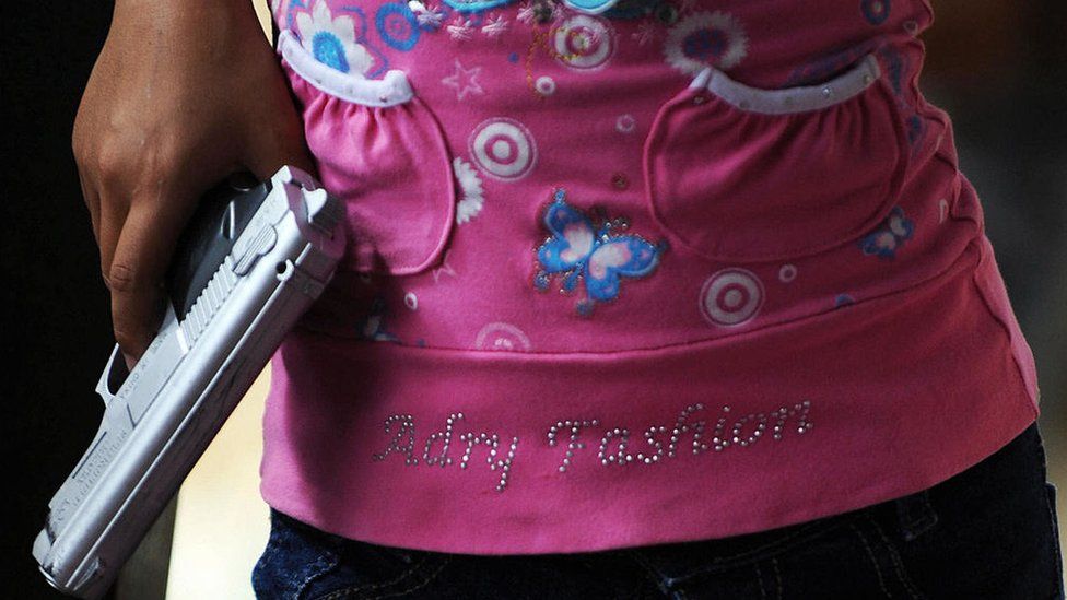 Una niña con una pistola de plástico