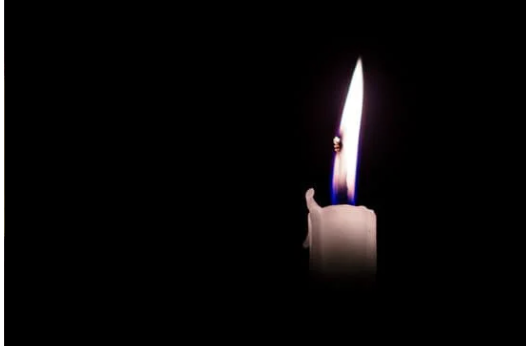 burning candle against a black background