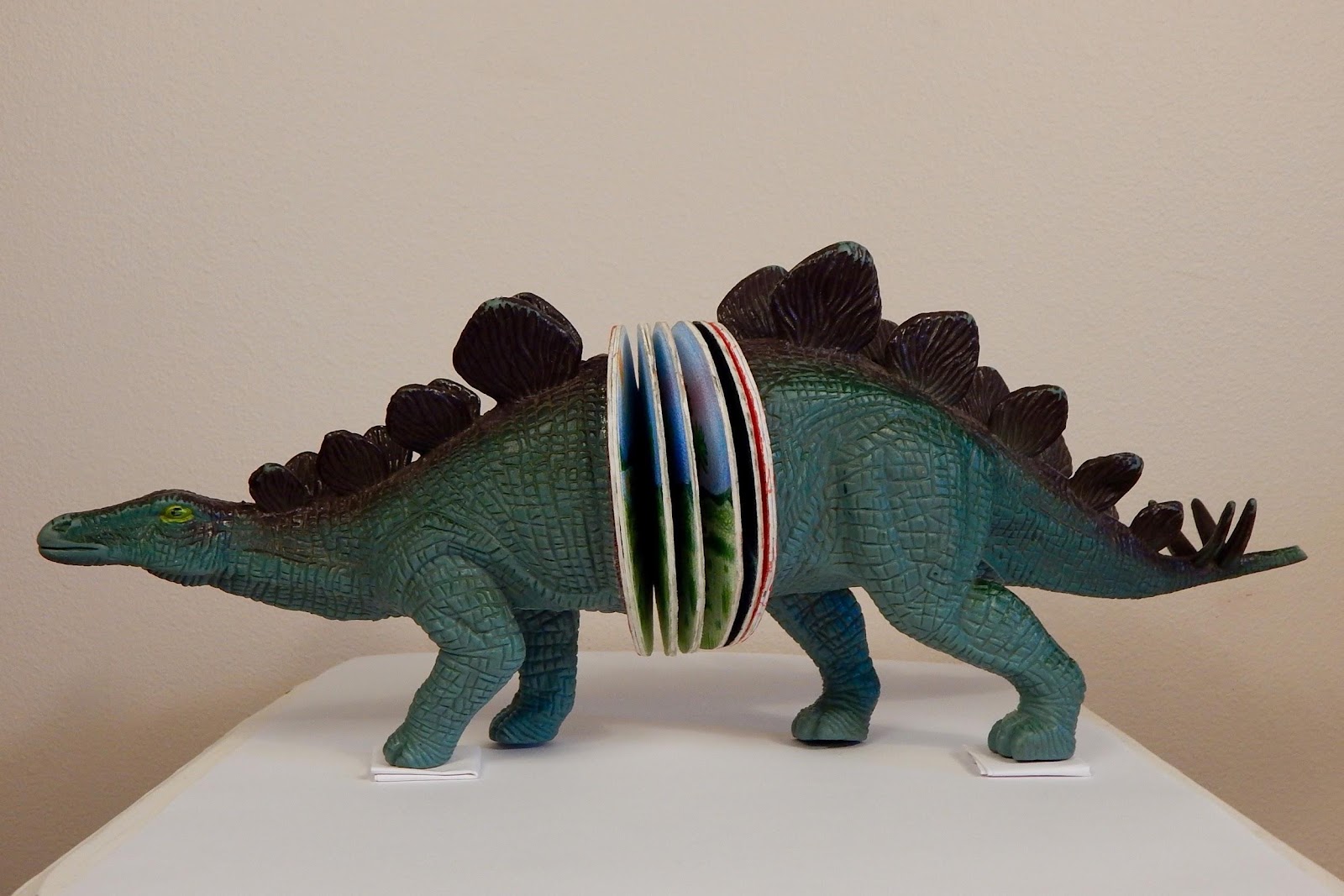 4" x 17"
Mixed Media: repurposed children's book, toy stegosaurus, paint, paper, colored pencil.