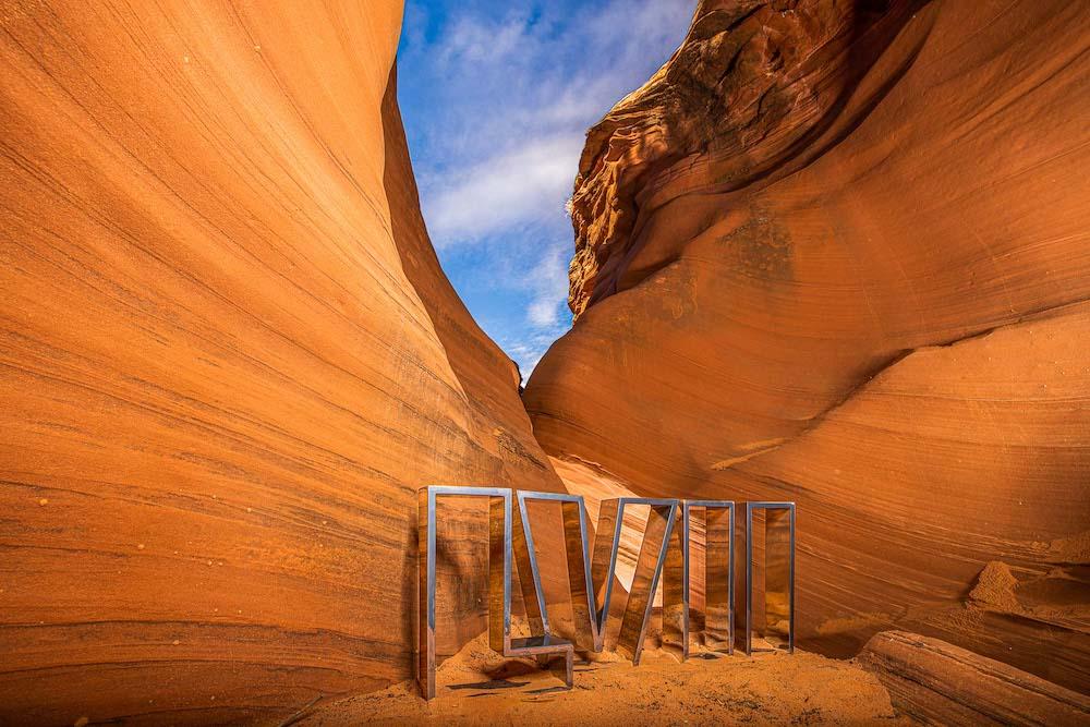 Photo of Arizona canyon sandy-red rock and bright blue skies, with steel Roman numerals in foreground by outdoor/adventure photographer Aaron Ingrao.