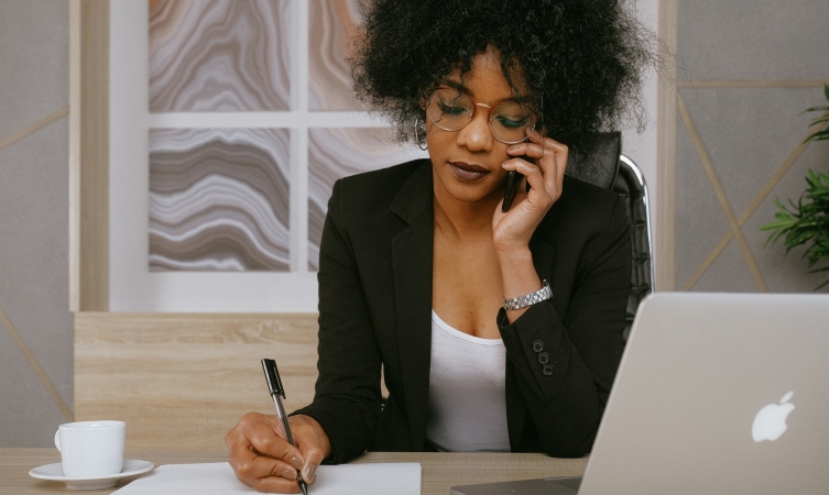 woman talking on her phone and taking notes