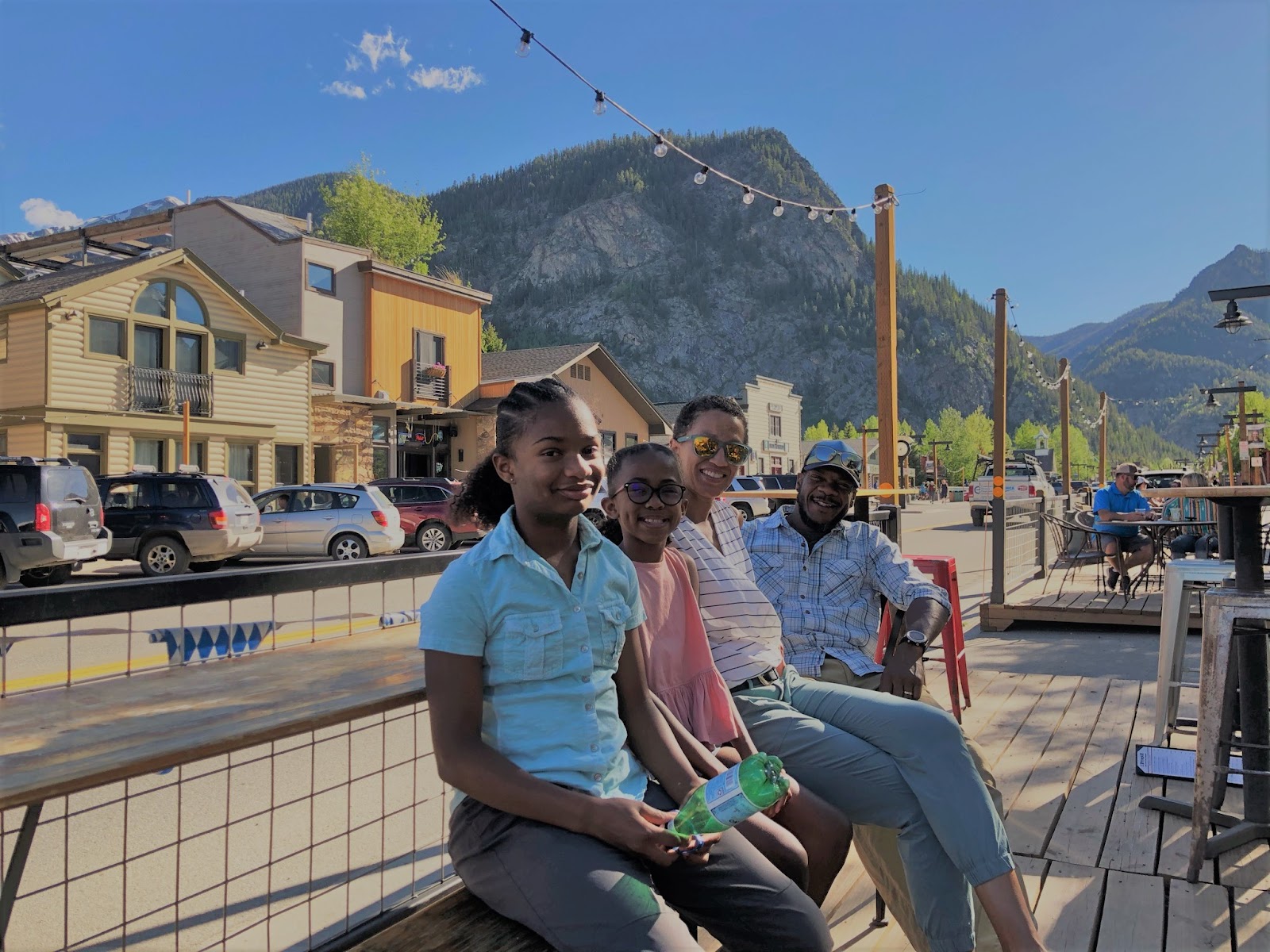 Family on a park bench next to the street.