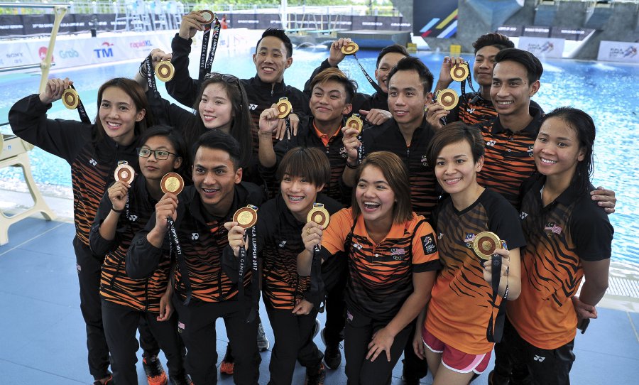 Malaysian divers show off their prizes after collecting all 13 gold medals in aquatic diving events of the 29th SEA Games at National Aquatic Centre in Bukit Jalil today. Bernama Photo