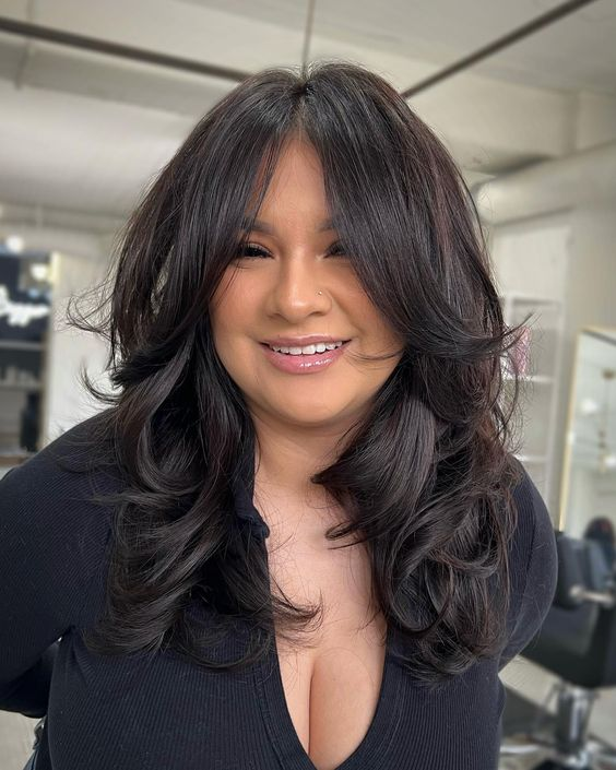 a lady smiling and showing her butterfly haircut