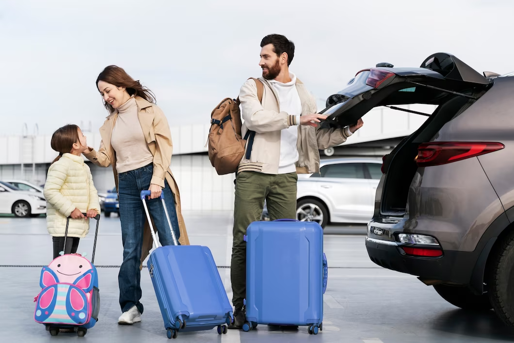 A mother, a father and a little girl taking their luggage to the car to go on a vacation. 