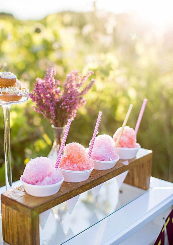 photo of pink snow cone display for outdoor wedding