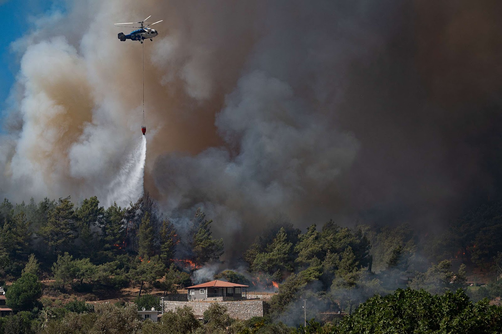 A firefighting helicopter drops water on a wildfire on August 2, 2021 near Marmaris, Turkey.