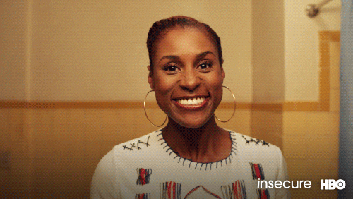 animated gif of issa rae looking at herself in the mirror trying to affirm herself. There is blue text at the bottom that says: "You look... great!"