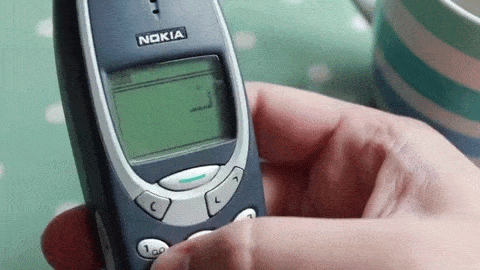 showing a motion picture a man playing snake game on an old nokia phone