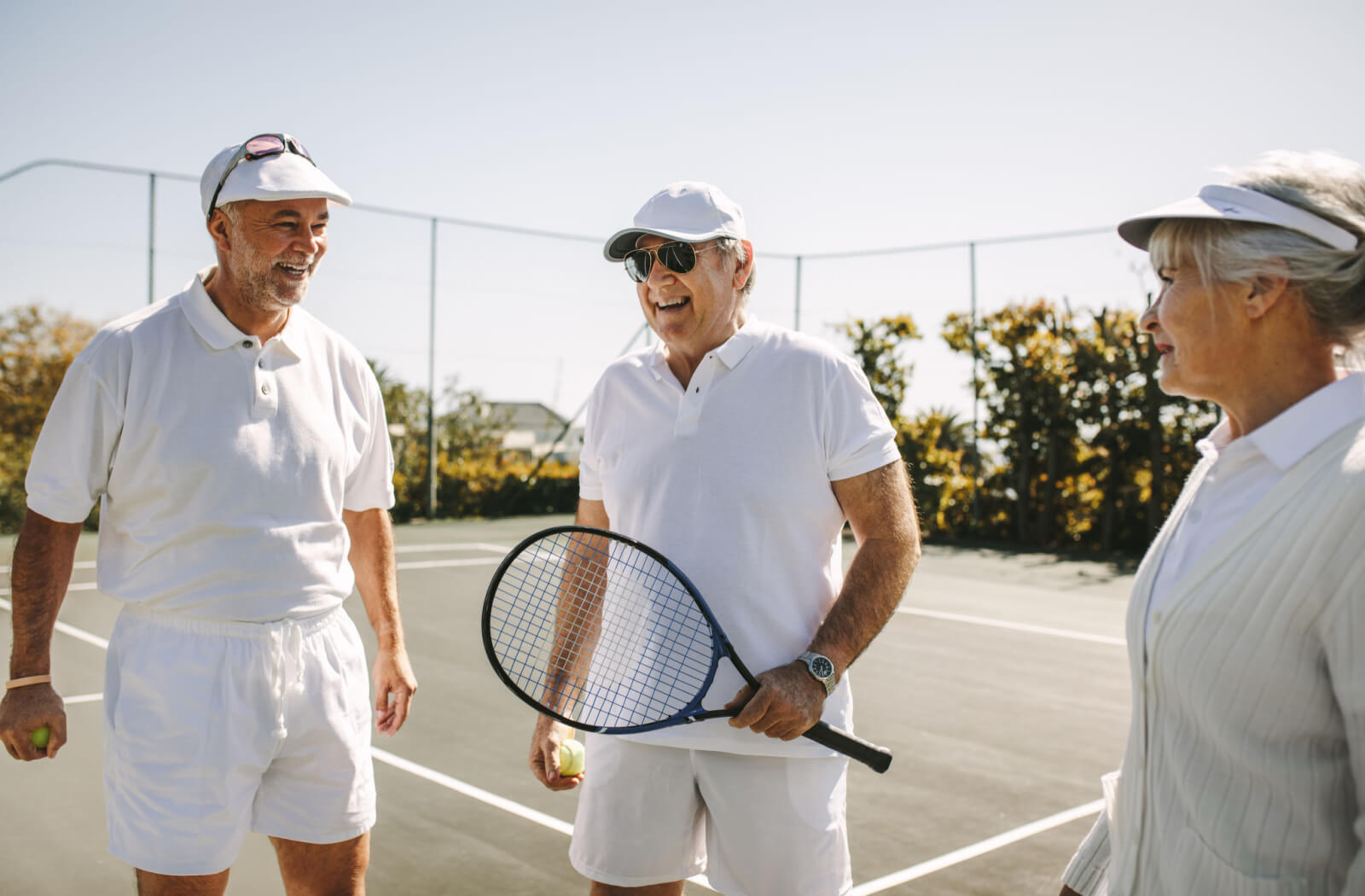 a group of seniors play tennis to keep active and socialize