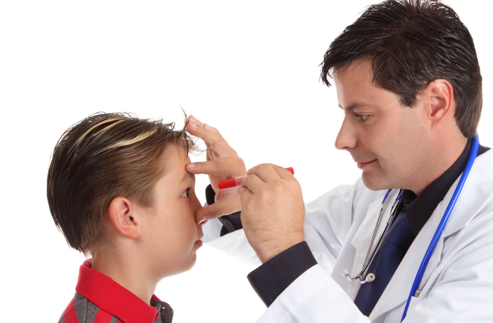 A male eye doctor is examining an eye of a boy, the doctor is holding a pen light on his left hand closed to the patient's eye.