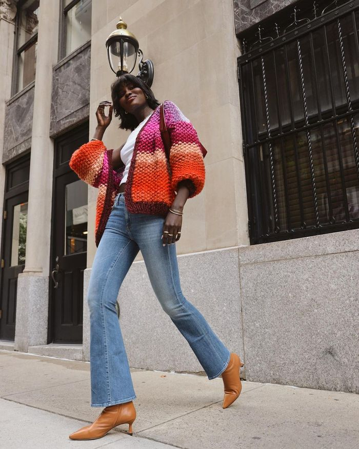 a black lady wearing bootcut jeans with a cardigan