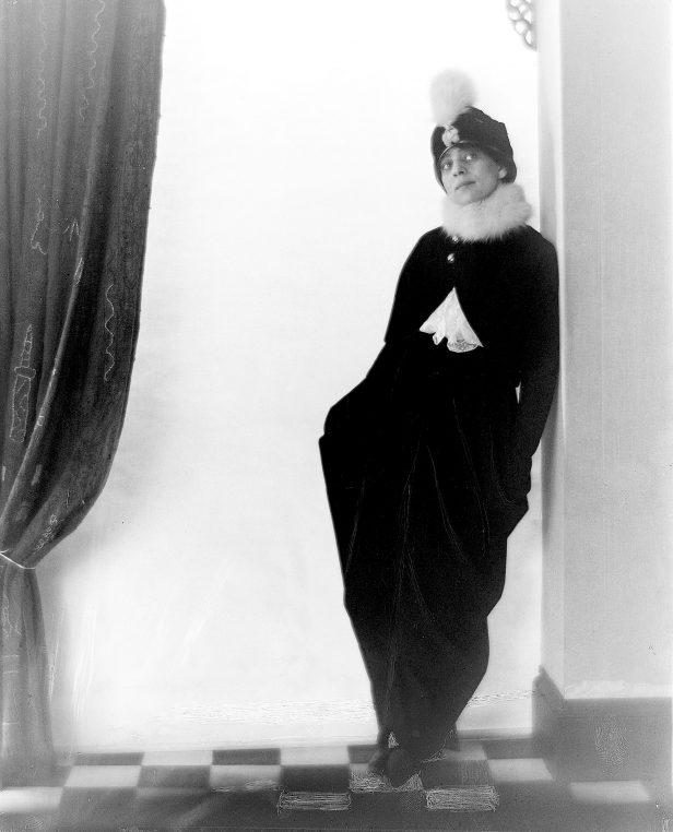 Greene wearing a plumed hat and dress inspired by Paul Poiret