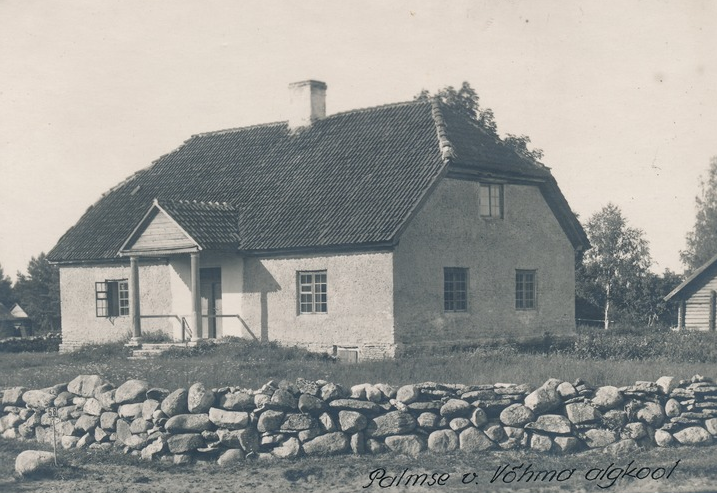 A herd of sheep grazing in front of a houseDescription automatically generated