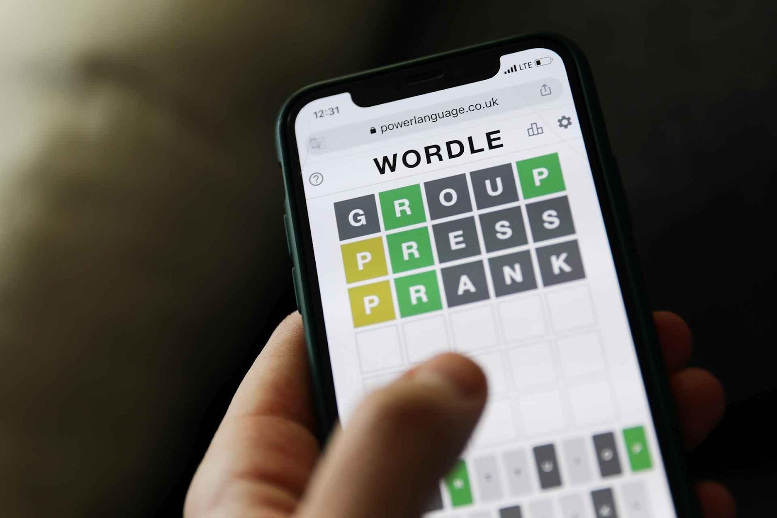 A hand holding a phone with a crossword puzzle

Description automatically generated