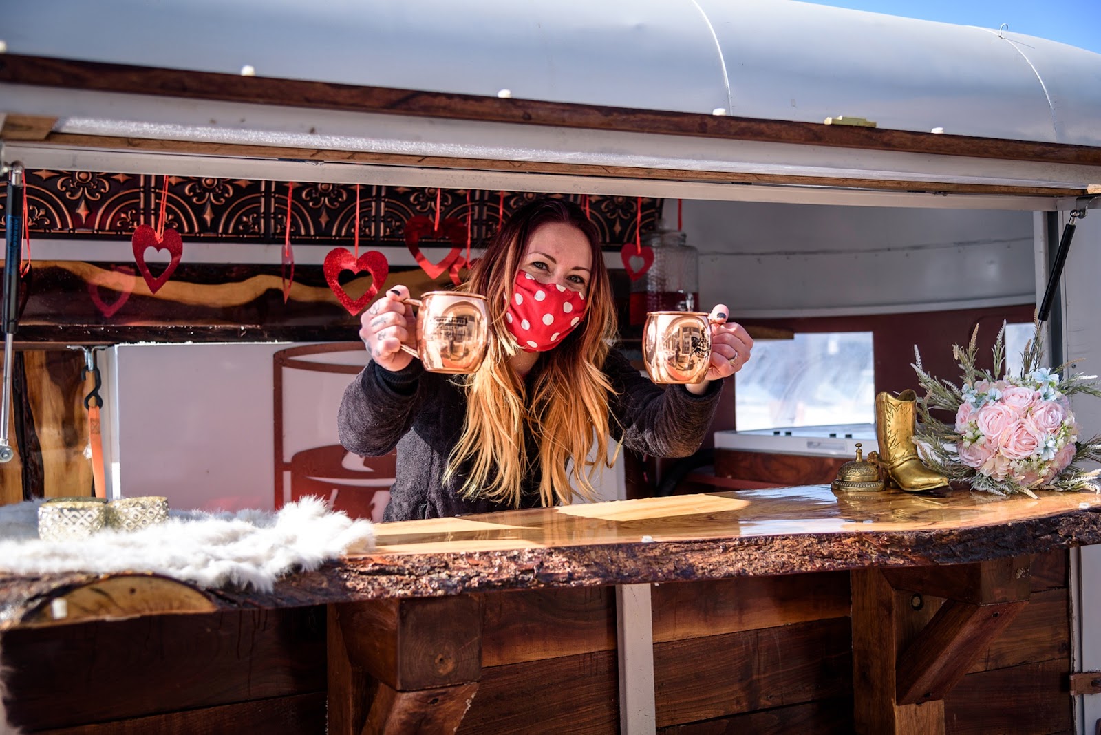 On the Rocks TIPS-certified bartender Tiffany wears a mask while holding two Moscow mules at a Valentine’s Day wedding during the pandemic.